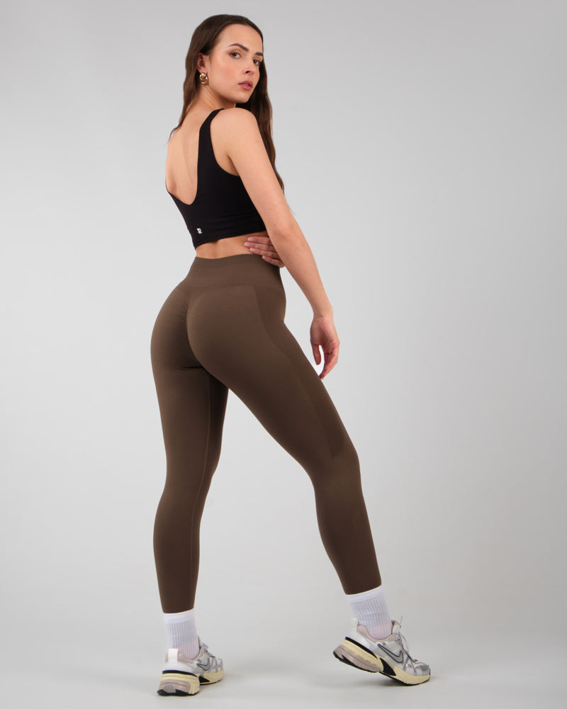 Modèle féminin portant le legging AMBER Mocha vu de côté, en posture de marche avec une jambe en avant.