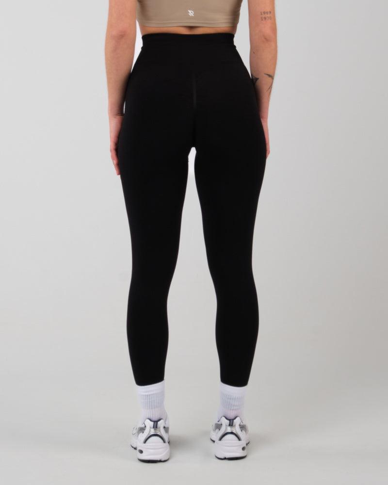 Modèle de dos portant le legging noir AMBER push-up, soulignant la coupe ajustée.