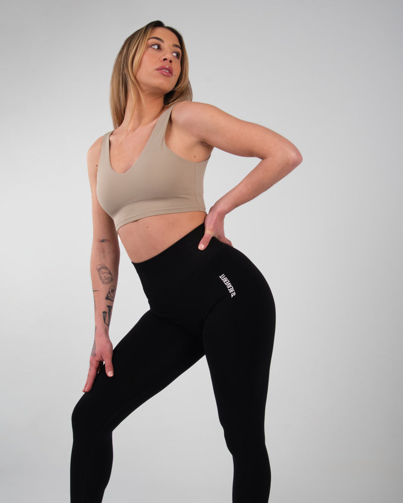 Modèle féminin en pose dynamique portant le legging noir taille haute AMBER.