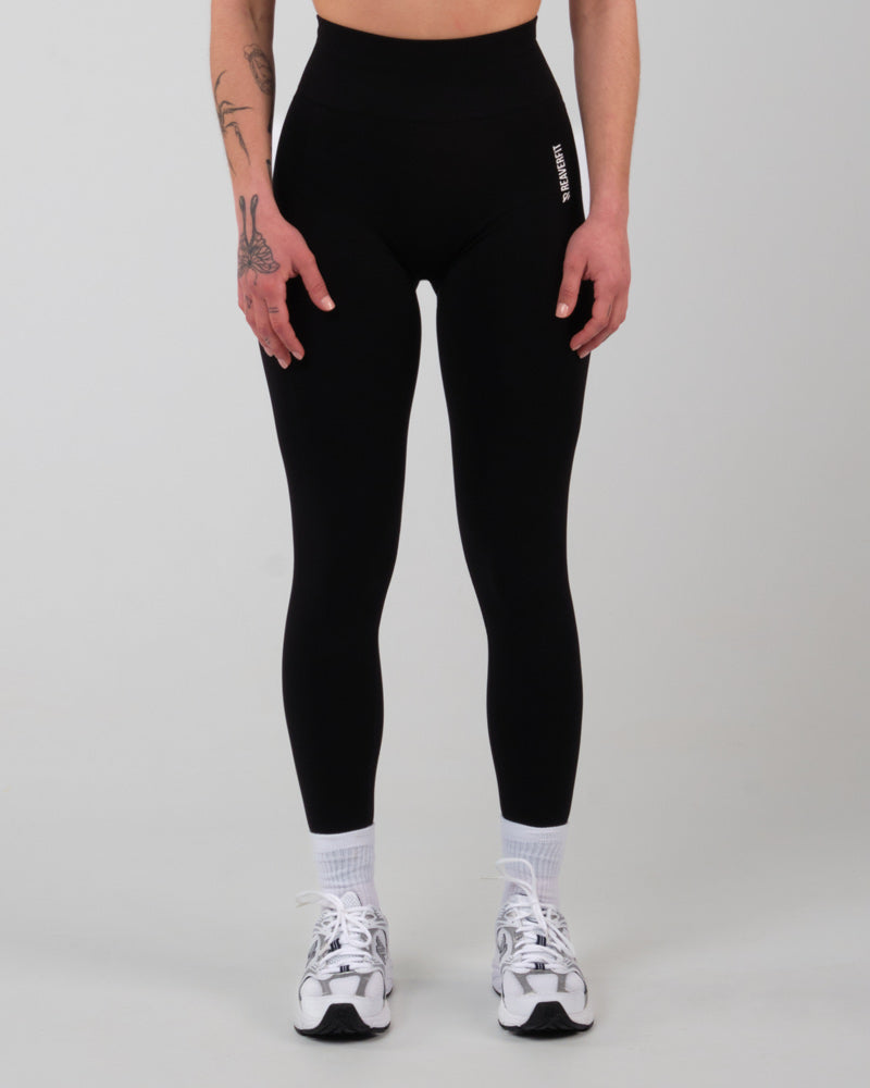 Modèle féminin faisant face à la caméra, portant le legging de sport push-up et taille haute AMBER en noir, montrant la coupe ajustée et la ceinture élastique pour un soutien optimal.