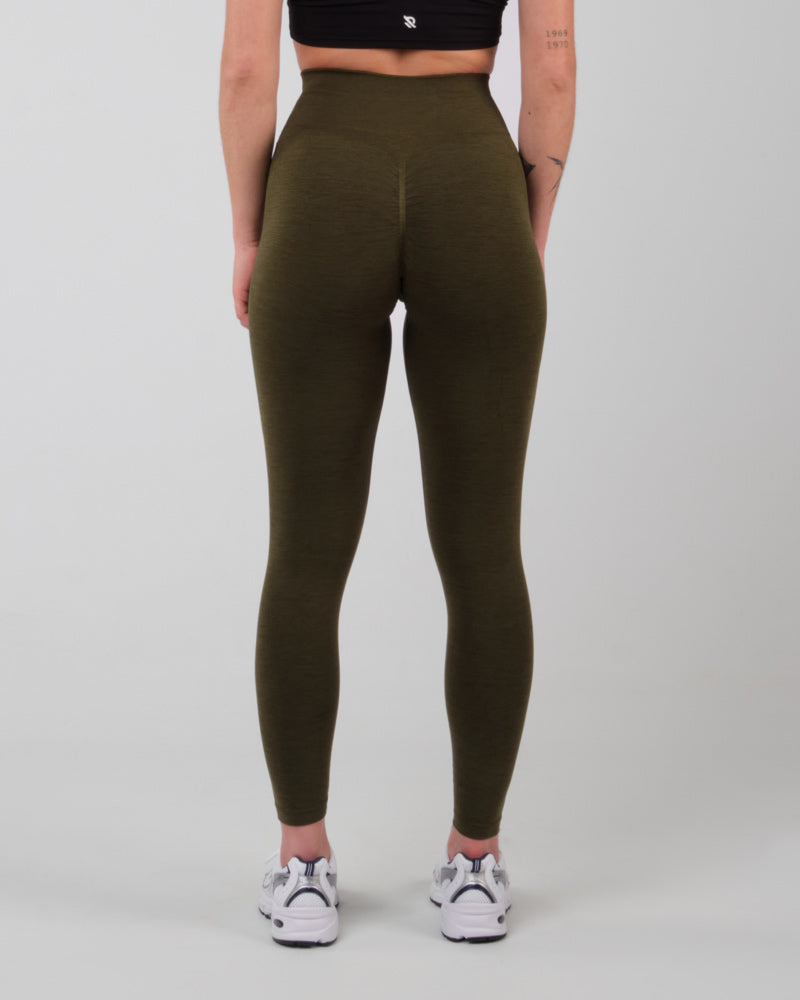 Modèle féminin de trois-quarts avant en legging AMBER olive, mettant en avant la coupe flatteuse et le design épuré.