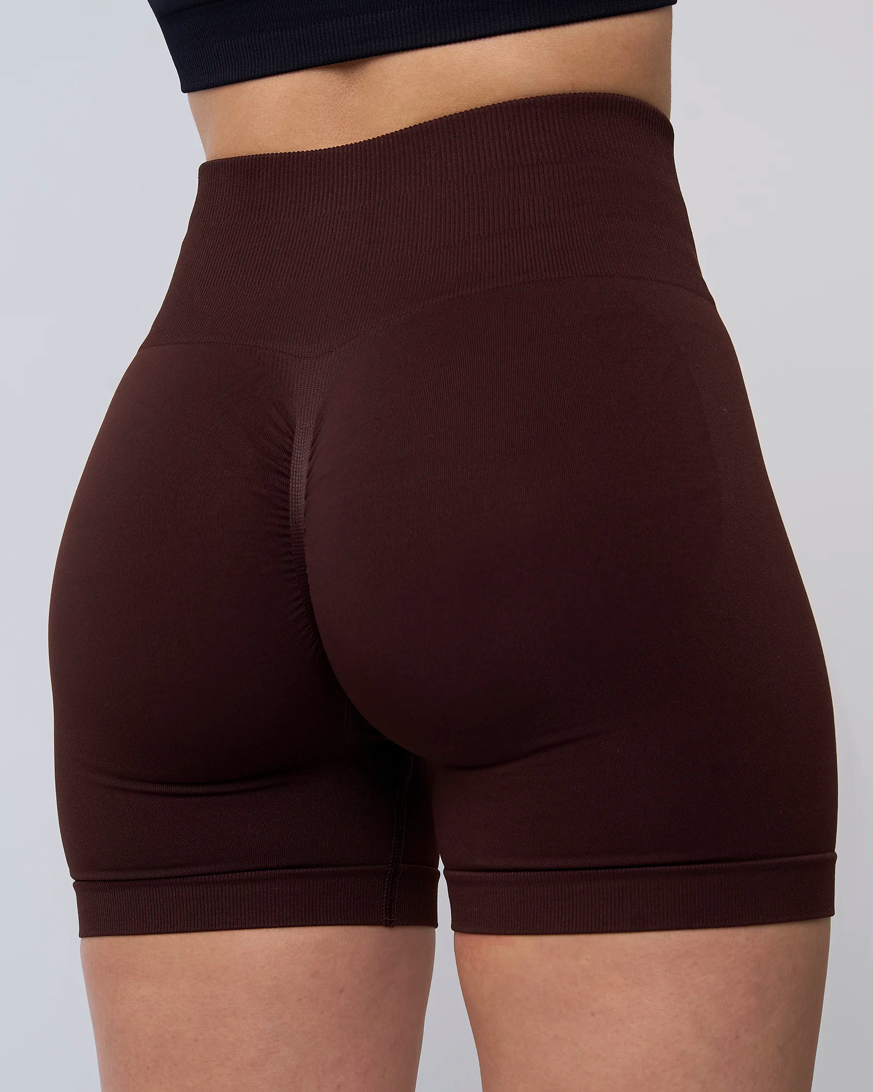 Short de sport Reaverfit en expresso pour femme, vue arrière, avec une ceinture haute et un tissu extensible pour un confort et un maintien pendant les séances de sport.