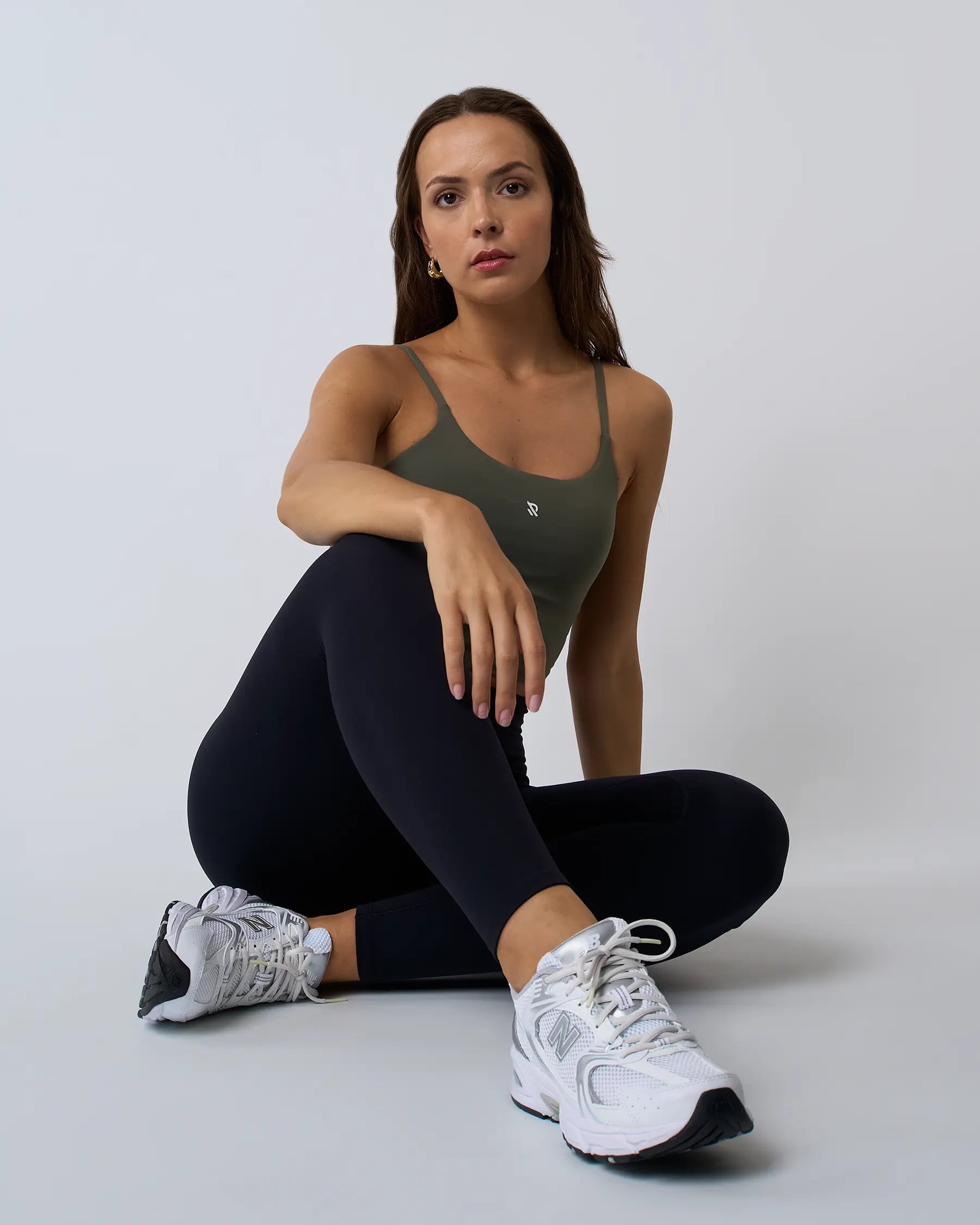 Modèle assis portant le crop top MYRA kaki avec brassière intégrée