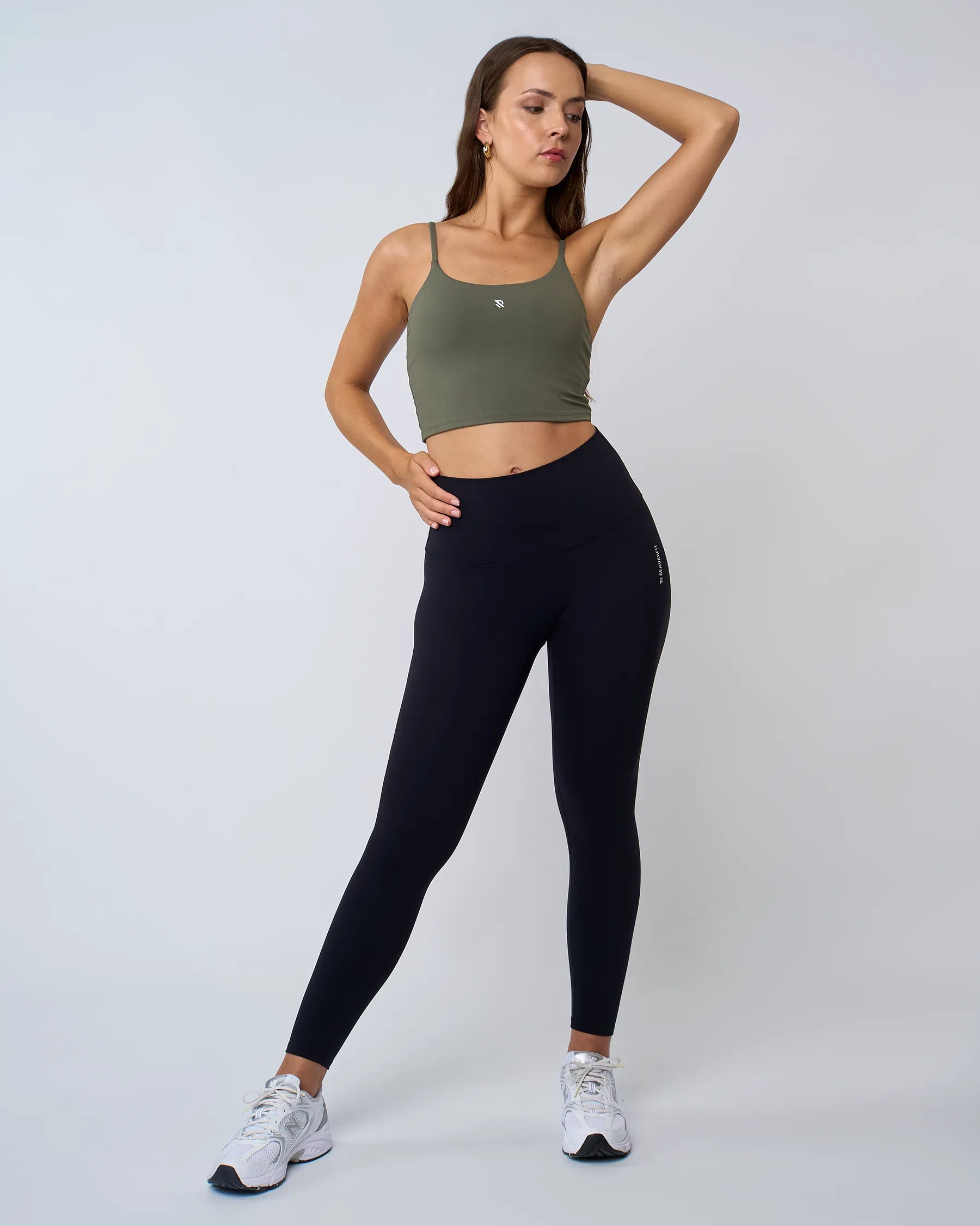 Vue de face du crop top MYRA kaki avec brassière intégrée, modèle avec bras en l'air