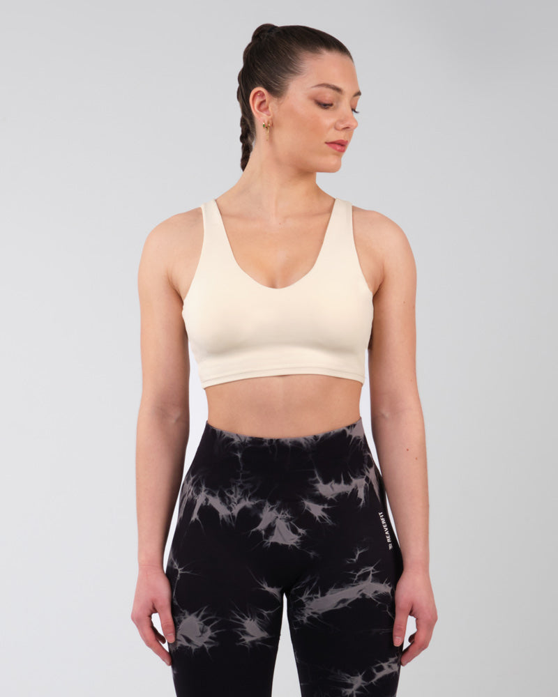 Brassière de sport crème vue de trois-quarts, soulignant la qualité et la coupe pour une performance athlétique optimale