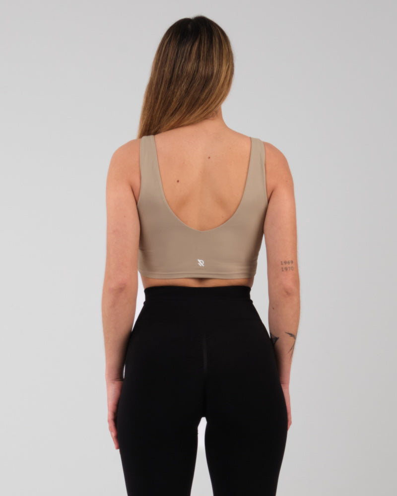 Vue arriere de la brassiere sportive Jane en camel, montrant la coupe ajustee et les details des bretelles pour le sport.