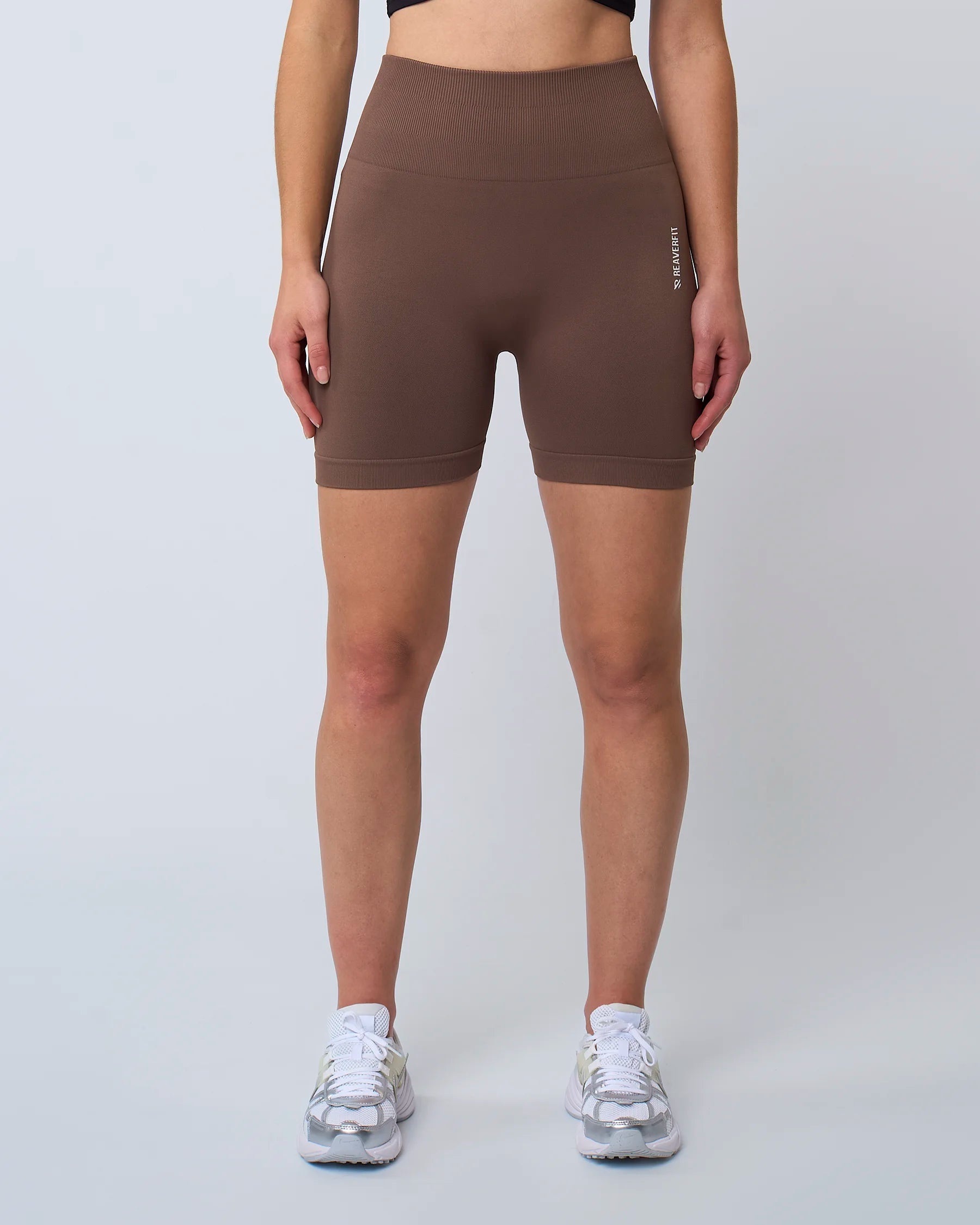 Femme debout portant un short sculpt mocha taille haute, coupe ajustée et sportive.