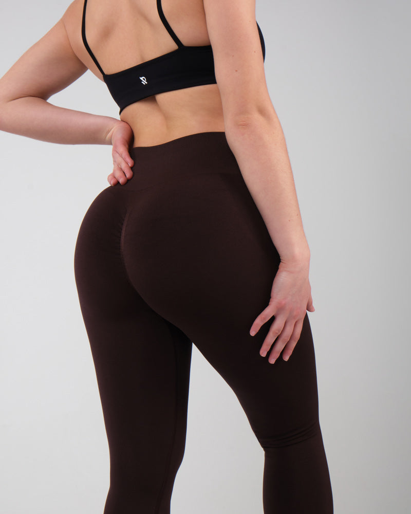 Modèle féminin présentant la coupe push-up du legging de sport AMBER marron.