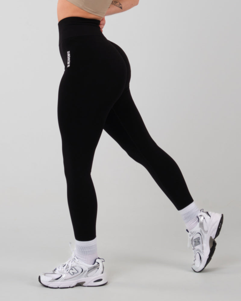 Vue de profil du legging de sport noir AMBER, mettant en évidence l'effet galbant sur les fessiers.