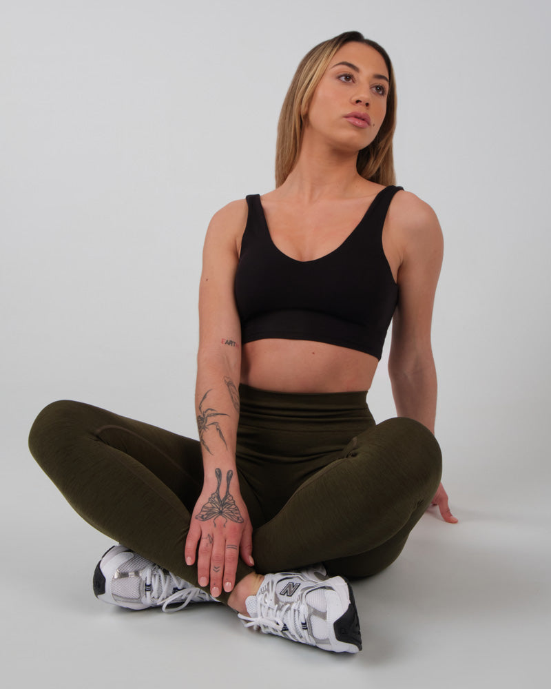 Brassière de sport Jane en noir portée en posture de méditation, mettant en avant confort et style pour l'entraînement de fitness.