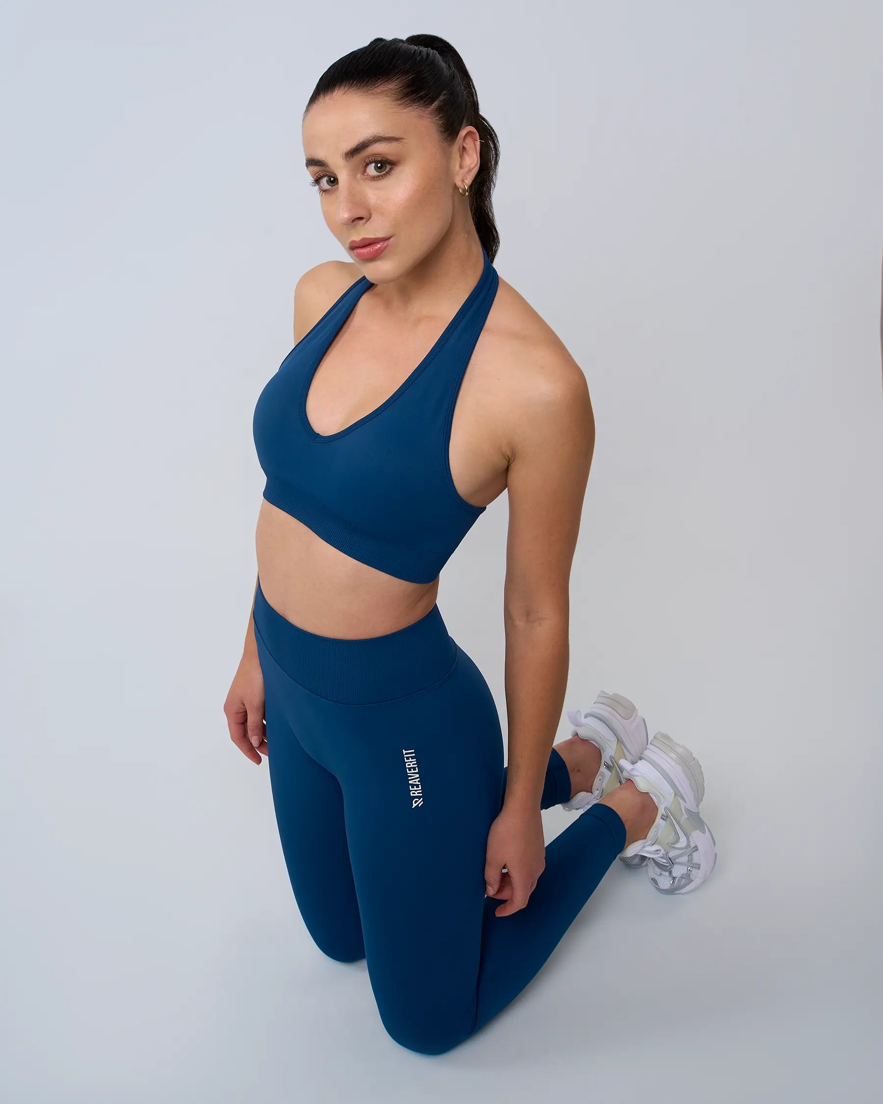 Femme accroupie portant le legging AZUR bleu Reaverfit, idéal pour les activités sportives variées.