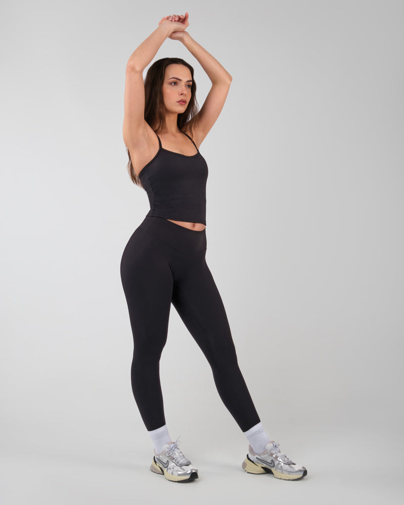 Sportive élégante dans une pose de yoga vêtue d'un legging ALMA noir parfait pour le fitness et la gym.