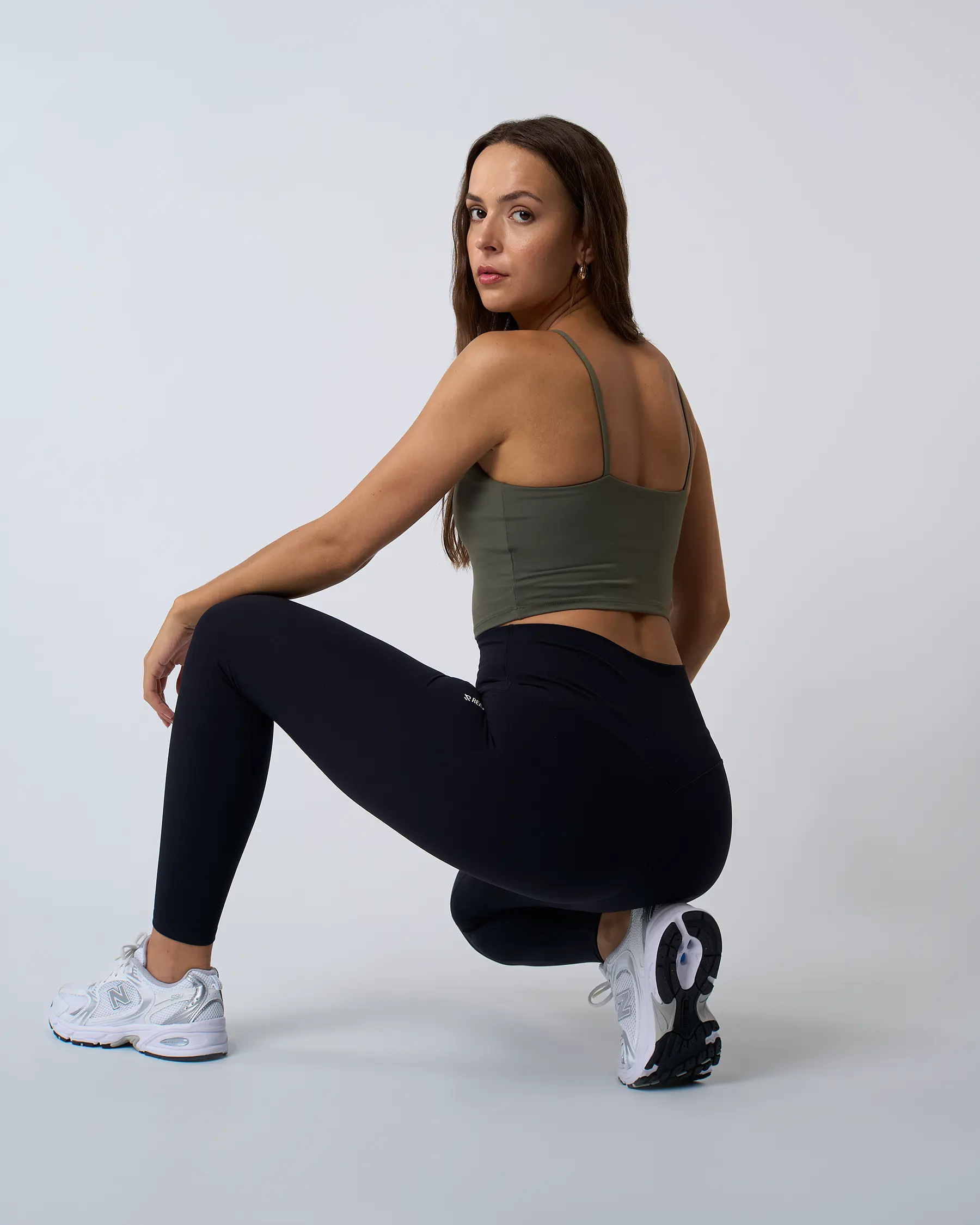 Legging de sport noir LUXE pour femme, assise, taille haute et confortable, conçu pour le confort pendant les étirements et le yoga.