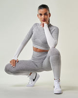 modele de sport femme qui pose avec un Crop Top de sport blanc gris à manches longues Tissu respirant et résistant aux traces de transpiration, Reaverfit